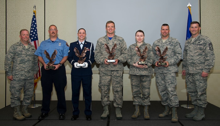 Col. Jeffrey DeVore, 628th Air Base Wing commander (left) and Chief Master Sgt. Mark Bronson, 628th Air Base Wing command chief (right), congratulate (left to right) Glen Pilger, Civilian Category I of the Quarter, Senior Airman Erin Winkler, Honor Guard Member of the Quarter, Capt. Phillip Hoyt, Company Grade Officer of the Quarter, Tech. Sgt. Lyudmila Mueller, NCO of the Quarter, and Master Sgt. Clinton Dunnehoo, Senior NCO of the Quarter during the 628th ABW quarterly awards ceremony Nov. 7, 2014, at the Charleston Club on Joint Base Charleston, S.C. The quarterly awards are held to recognize outstanding Airmen, NCOs, senior NCOs, company grade officers and civilians for their hard work and dedication. (U.S. Air Force photo/Airman 1st Class Clayton Cupit)