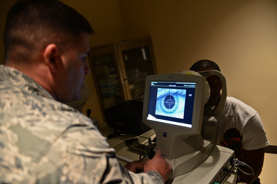 Master Sgt. Mark Slater, 28th Medical Operations Squadron NCO in charge of optometry, administers a corneal topography test to Airman 1st Class Jordan Fishburn, 28th Logistics Readiness Squadron aircraft parts store technician, during a pre-operation procedure in the optometry clinic at Ellsworth Air Force Base, S.D., Oct. 24, 2014. The test maps a patient’s cornea for raised areas and surface inconsistencies to prevent infections or degenerative diseases. (U.S. Air Force photo by Senior Airman Zachary Hada/Released)