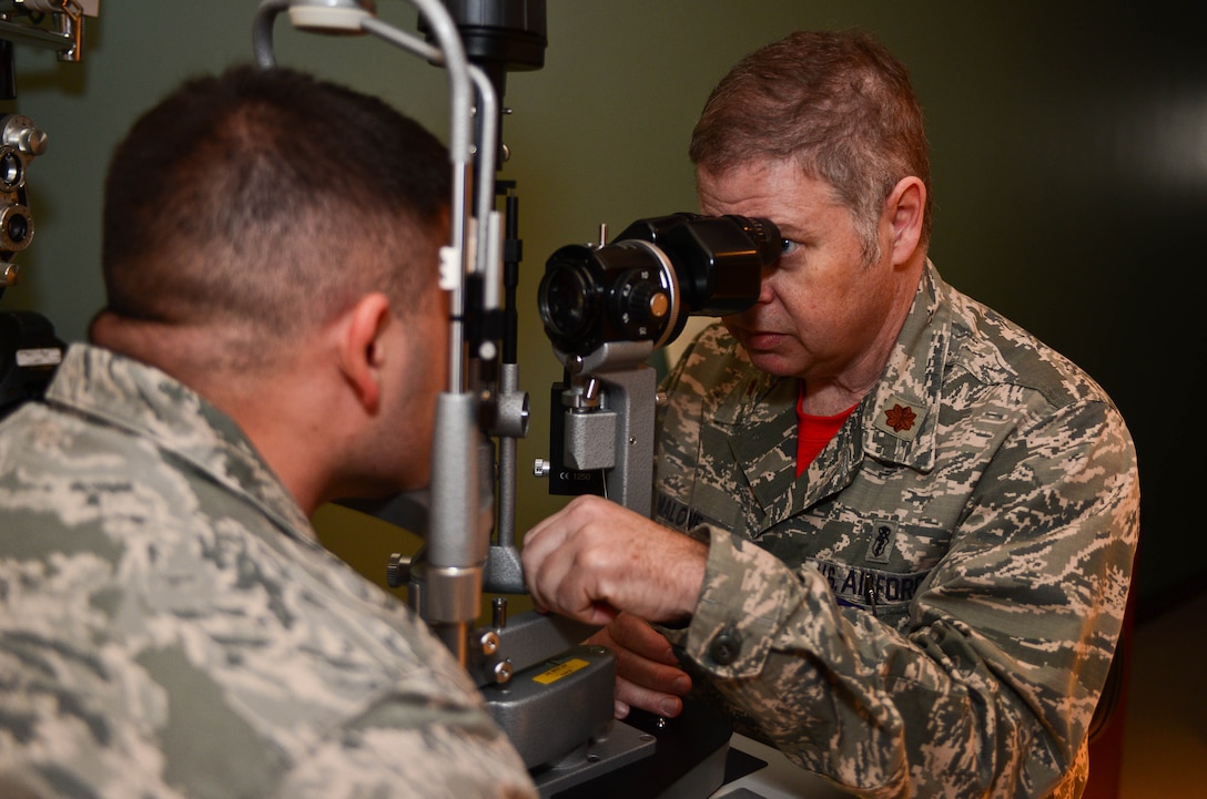 Maj. Charles Malone, 28th Medical Operations Squadron optometrist, performs a slit lamp test on Master Sgt. Mark Slater, 28th MDOS NCO in charge of optometry, at Ellsworth Air Force Base, S.D., Oct. 24, 2014. Slit lamps provide the optometrist with a magnified view of the internal and external portions of the eye to identify cuts, scrapes, tears, foreign objects or infections. (U.S. Air Force photo by Senior Airman Zachary Hada/Released)