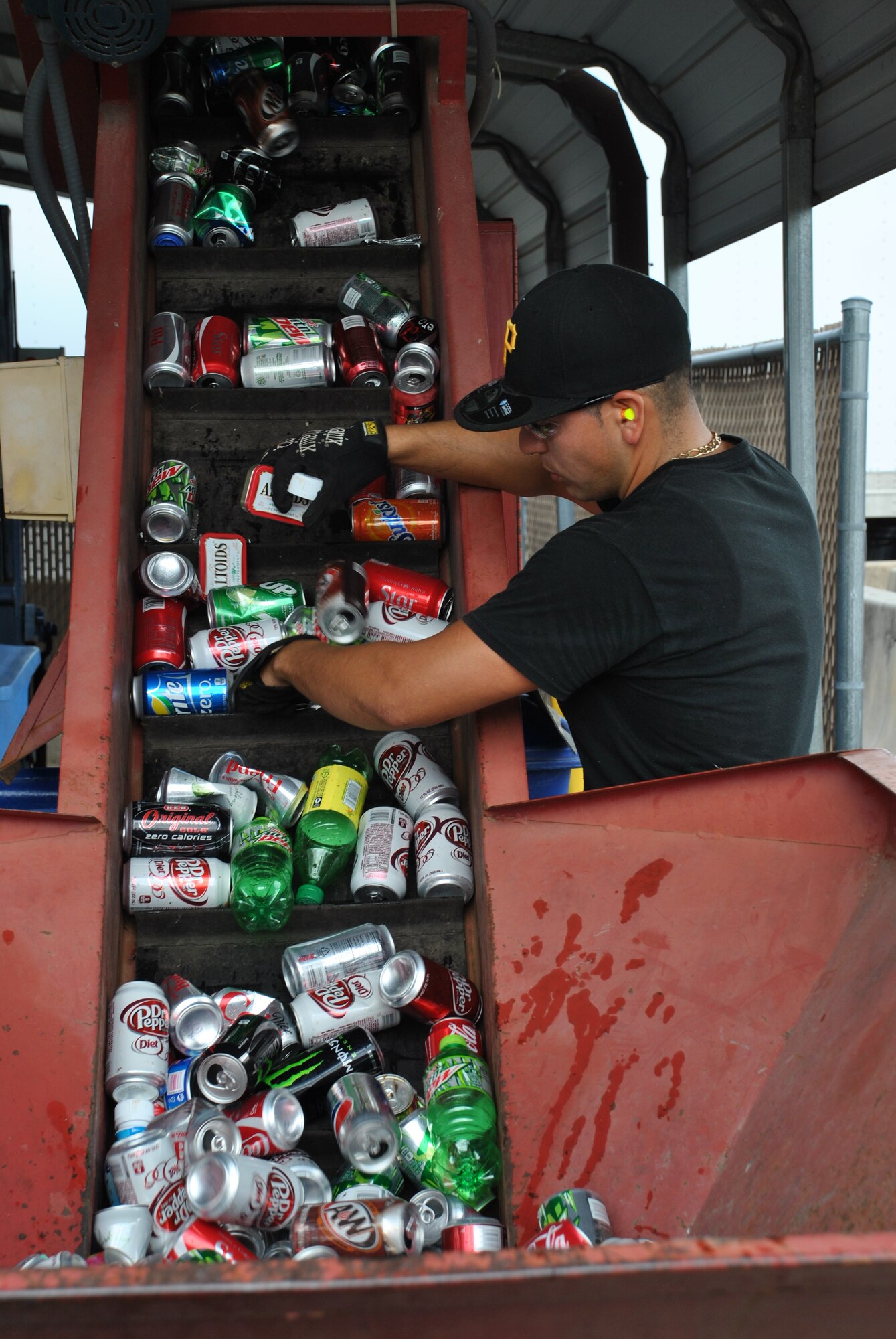 A Joint Base San Antonio-Lackland Recycling Center worker readies cans for recycling. The installation operates a zero-cost recycling program, using revenue generated from the program to pay operating, maintenance and salary costs. (U.S. Air Force photo/Jennifer Schneider/Released)