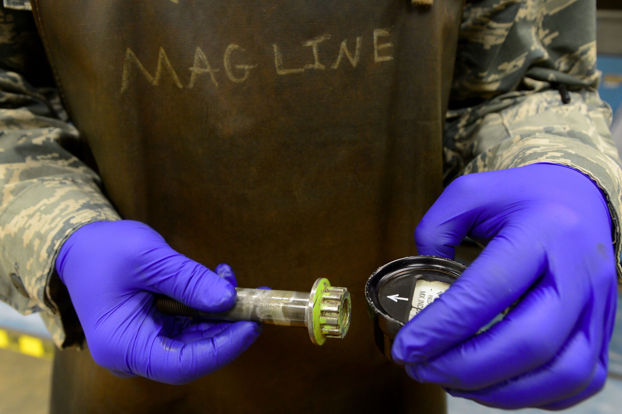 An Airman assigned to the 20th Equipment Maintenance Squadron non-destructive inspection shop, holds a field indicator near an F-16CM Fighting Falcon wing attachment bolt to check the magnetization at Shaw Air Force Base, S.C., Nov. 3, 2014. At the end of a magnetic particle inspection, Airmen ensure parts are de-magnetized by testing each side with a field indicator. (U.S. Air Force photo by Airman 1st Class Jensen Stidham/Released)