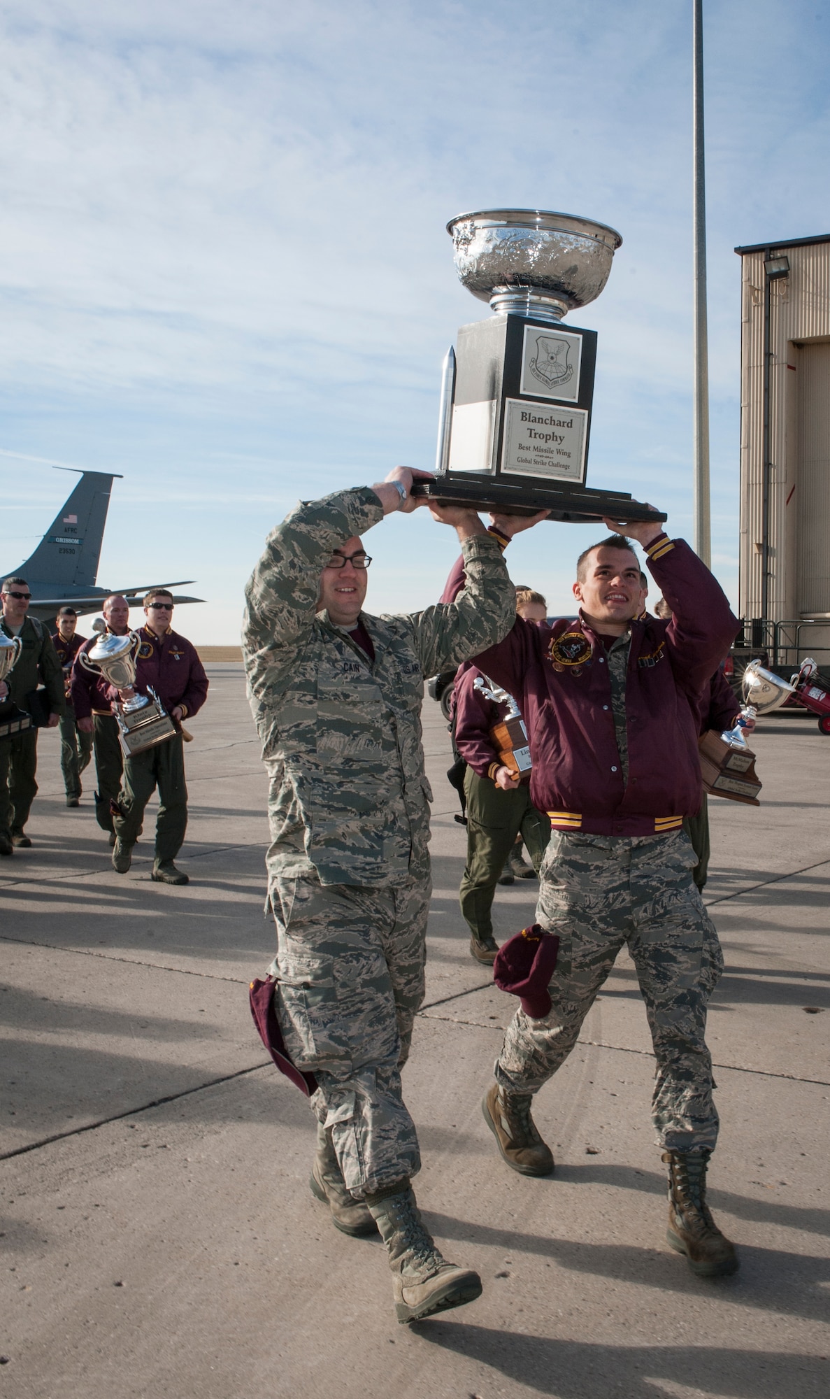 Senior Airman Brandon Cain, 91st Missile Maintenance Squadron Global Strike Challenge team member and Airman 1st Class Robert Cook, 91st Missile Operations Squadron GSC team member, carry the Blanchard Trophy towards a crowd of cheering 91st Airmen after returning from the GSC score posting on Barksdale Air Force Base, La.  The Blanchard Trophy is awarded to the best missile wing in the Air force and this was the second year in a row that Minot brought home the prestigious award. (U.S. Air Force photo/Senior Airman Stephanie Morris)