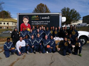 Members of the U.S, Air Force and Navy Honor Guards pose for a group photo Nov. 8, 2014, at the Capital Area Food Bank in Lorton, Va. Guardsmen from both military branches assembled 750 bags of donated food estimated to feed up to 2,800 people this Thanksgiving. (Courtesy photo/Michelle Kuzenko)