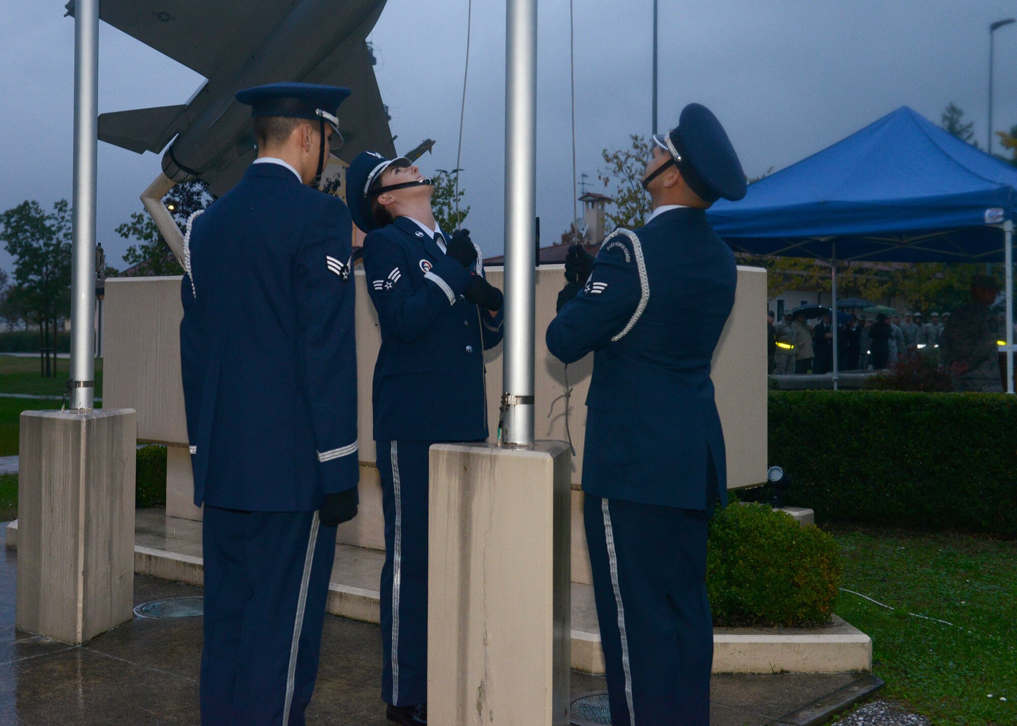 (From left) Senior Airmen Hector Chacon, Tiffany Knippelberg and Roni Choueiry, 31st Force Support Squadron honor guardsmen raises the flag for reveille during a Veterans Day Ceremony, Nov. 10, 2014, at Aviano Air Base, Italy. Veterans Day is observed annually on November 11 and honors those who have served in the U.S. armed services. (U.S. Air Force photo/Airman 1st Class Deana Heitzman)