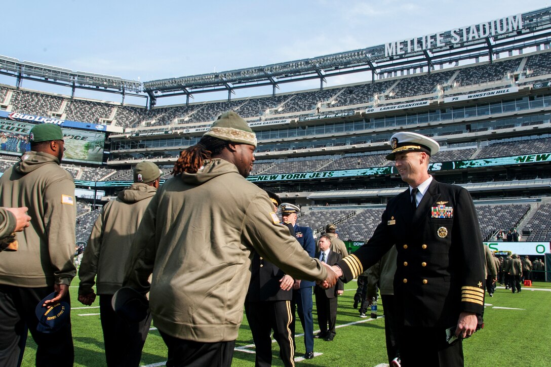 Navy Capt. Gregory Davis, right, commander of Navy Operational Support Center New York City, shakes the hands of New York Jets players during a pre-game player walk at MetLife Stadium in East Rutherford, N.J., Nov. 9, 2014.    
