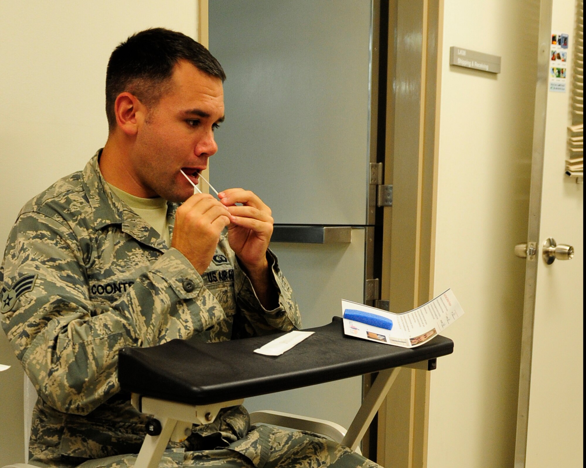 U.S. Air Force Senior Airman Aaron Coonts, 18th Operation Support Squadron air traffic control journeyman, uses cotton swabs to extract skin cells within his mouth to be sent for the C.W. Bill Young Department of Defense Marrow Donor Program on Kadena Air Base, Japan, Nov. 4 2014. The applications are sent to the program where the DNA is collected, tested and stored in a database. By applying, members are registering to be put on a list of possible matches to potentially donate bone marrow in the future if found compatible with a patient in need. (U.S. Air Force photo by Airman 1st Class Keith James/Released)