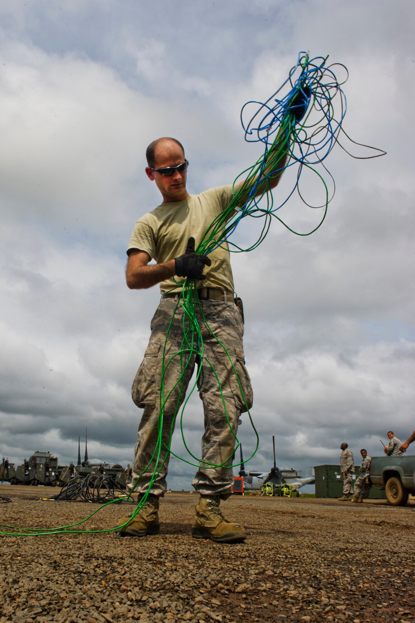 U.S. Air Force Staff Ben Meltzer from the Joint Task Force-Port Opening assigned to the 621st Contingency Response Wing stationed at Joint Base McGuire-Dix-Lakehurst, N.J., gathers communication wires as he prepares equipment for re-deployment after completing their mission at Roberts International Airport, Republic of Liberia, during Operation UNITED ASSISTANCE, Nov. 9, 2014. The JTF-PO established a hub for cargo distribution to help alleviate the increased traffic of airflow and cargo during OUA, a Department of Defense operation in Liberia to provide logistics, training and engineering support to U.S. Agency for International Development-led efforts to contain the Ebola virus outbreak in western Africa. (U.S. Air Force photo/Staff Sgt. Gustavo Gonzalez/RELEASED)