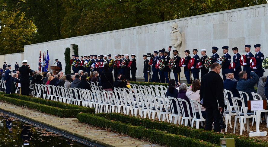 Service members from the 501st Combat Support Wing stand before a crowd of more than 50 guests during a Veterans Day ceremony at Cambridge American Cemetery, United Kingdom, Nov. 11, 2014. The Service members bore donated wreaths during the ceremony to recognize veterans both past and present. (U.S. Air Force photo by Tech. Sgt. Chrissy Best/Released)