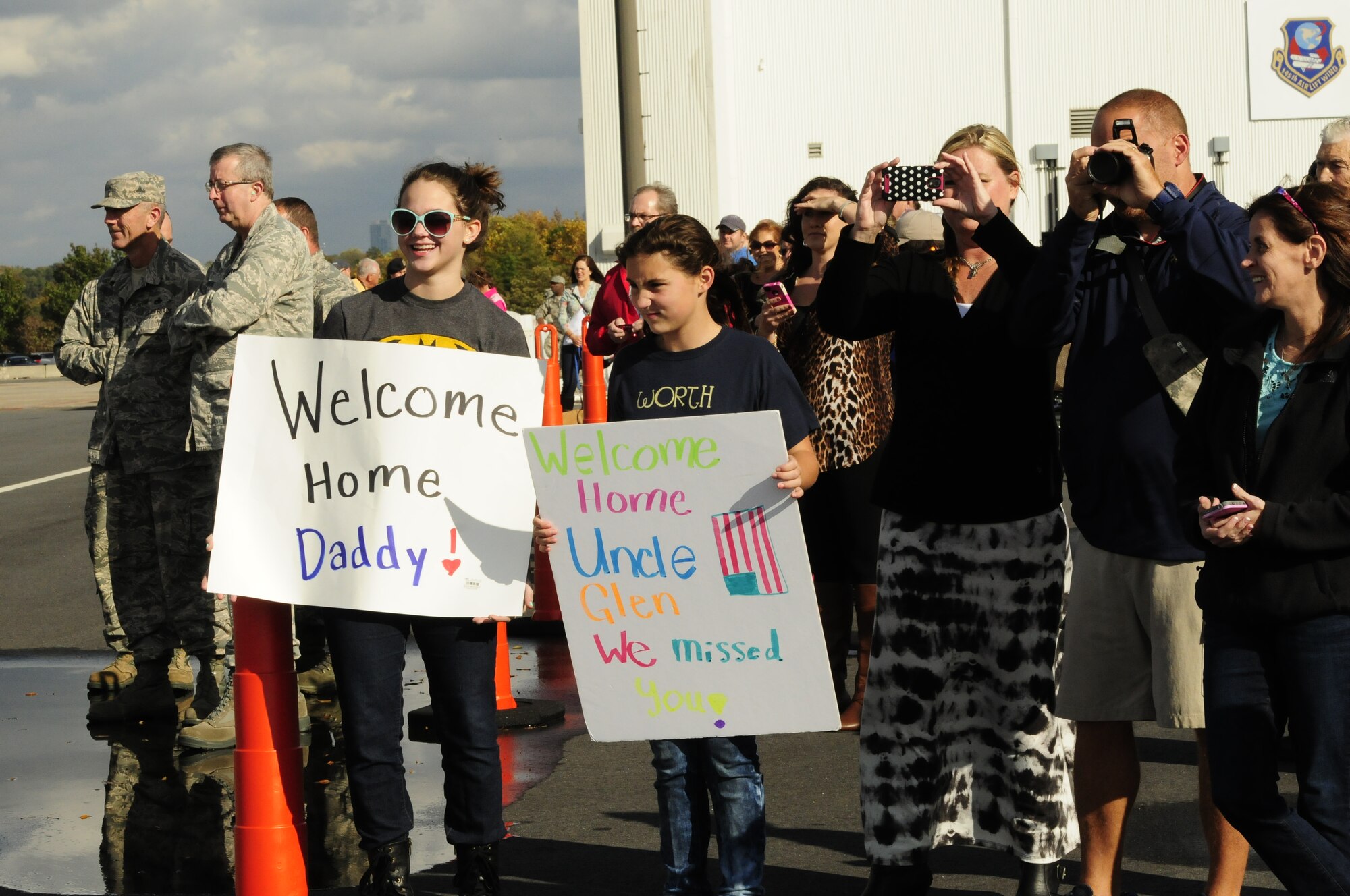 Family members and friends eagerly await the arrival of airmen from the 145th Airlift Wing as they return home to the North Carolina Air National Guard base, Charlotte Douglas Intl Airport, Nov 6, 2014. Over 90 airmen served 120 days while deployed to Qatar where they flew humanitarian supply air drops on Mt. Sinjar in Iraq. They conducted several resupply airdrops to the Iraqi Security Forces and engaged in battle with ISIS. (U.S. Air National Guard photo by Master Sgt. Patricia F. Moran, 145th Public Affairs/Released)