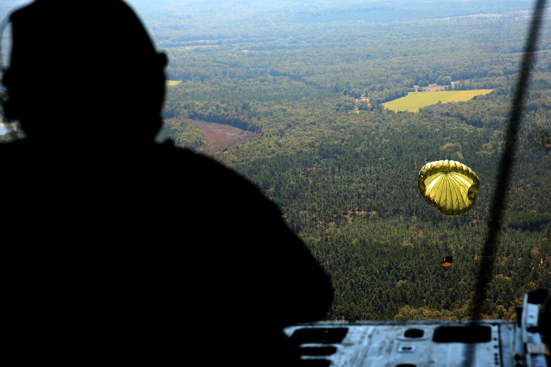 Master Sgt. James R. Holdaway watches a container delivery system drift toward a drop zone prior to airborne training at Fort Benning, Ga., Oct. 25, 2014. Holdaway is a crew master with Marine Aerial Refueler Transport Squadron 252 and assisted more than 180 airborne school students from several military branches complete static-line and military free fall jumps.