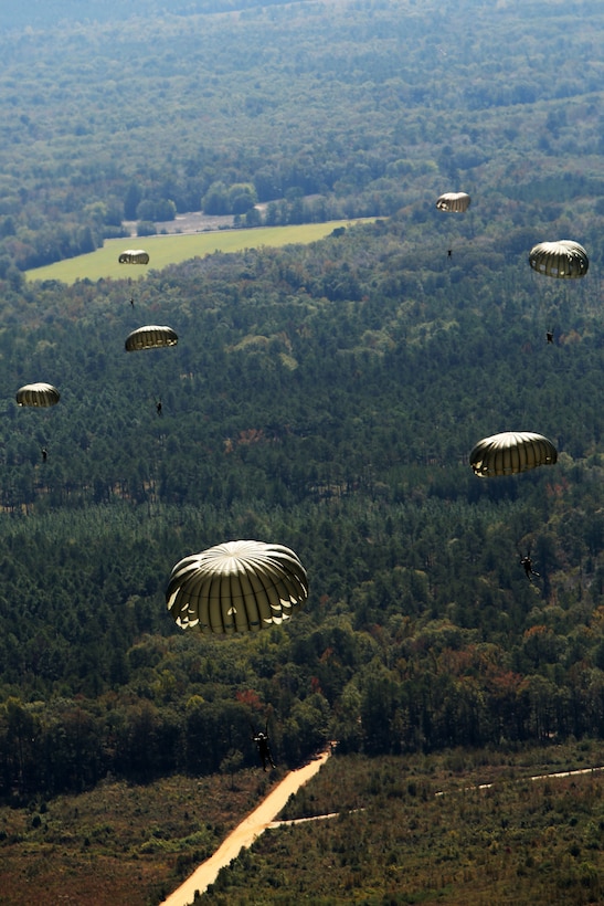 Students with the Basic Airborne School, 1st Battalion, 507th Parachute Infantry Regiment, drift toward a drop zone after exiting a KC-130J Super Hercules at Fort Benning, Ga., Oct. 25, 2014. The Marines of Marine Aerial Refueler Transport Squadron 252 supported airborne students during a training deployment for an upcoming operational deployment with the Special Purpose Marine Air-Ground Task Force Crisis Response.