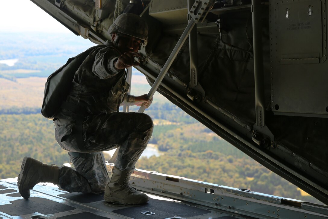 A jump master with 1st Battalion, 507th Parachute Infantry Regiment, gives the 30-second signal for jumpers at Fort Benning, Ga., Oct. 25, 2014. More than 180 airborne school students from several military branches complete static-line and military free fall jumps out the back of a KC-130J Super Hercules belonging to Marine Aerial Refueler Transport Squadron 252. The jump training was a part of the squadron’s training deployment for an upcoming operational deployment with the Special Purpose Marine Air-Ground Task Force Crisis Response.