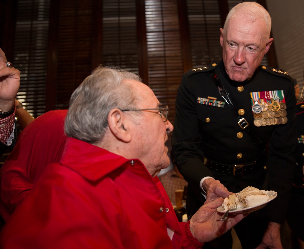 Lt. Gen. Richard P. Mills (right), commander of Marine Forces Reserve, offers a slice of cake to Milton R. West, Sr. (left), the oldest Marine present at a Marine Corps birthday celebration at Luke Restaurant in New Orleans, Nov. 10, 2014. It is customary for the guest of honor to offer a piece of cake to the oldest and youngest Marines present as a symbol of the passing of traditions. 