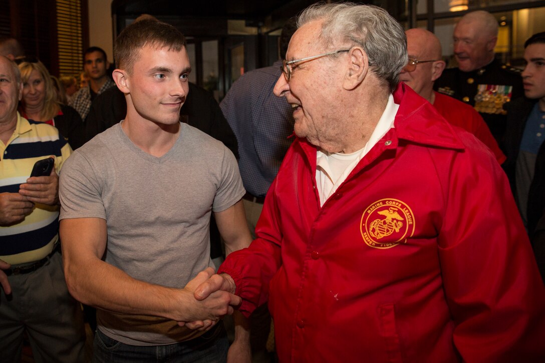 Cpl. Eric C. Adams (left), an administrative clerk with Marine Forces Reserve G-1, shakes hands with Milton R. West, Sr. (right), a Marine veteran of the Korean War, at a Marine Corps birthday celebration at Luke Restaurant in New Orleans, Nov. 10, 2014. Adams and West were the youngest and oldest Marines present at the celebration. 