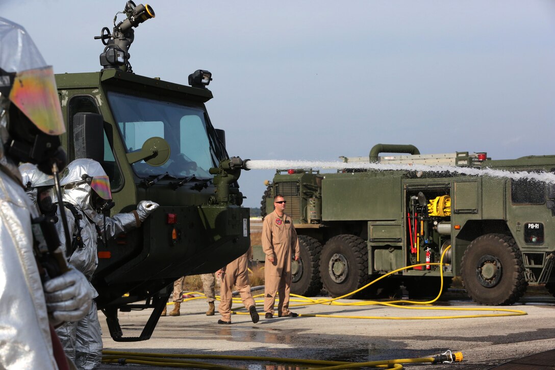 Aircraft rescue firefighting hose down a contained fire during evaluations of a new P-19 firefighting vehicle at Marine Corps Air Station Cherry Point Oct. 28, 2014. The evaluations will determine if the P-19 will be distributed through the Marine Corps. 
