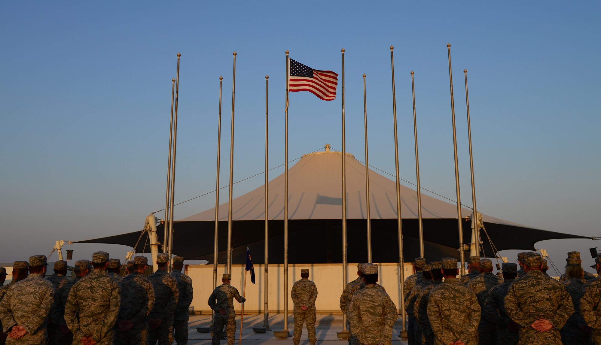 U.S. Air Force Airmen from the 379th Expeditionary Medical Group stand at parade rest during a retreat ceremony in honor of U.S. Servicemembers on Veteran’s Day, Nov. 11, 2014, at Al Udeid Air Base, Qatar. Joint remembrance ceremonies were held throughout the day in honor of Veteran’s and Remembrance Day. (U.S. Air Force photo by Senior Airman Kia Atkins)