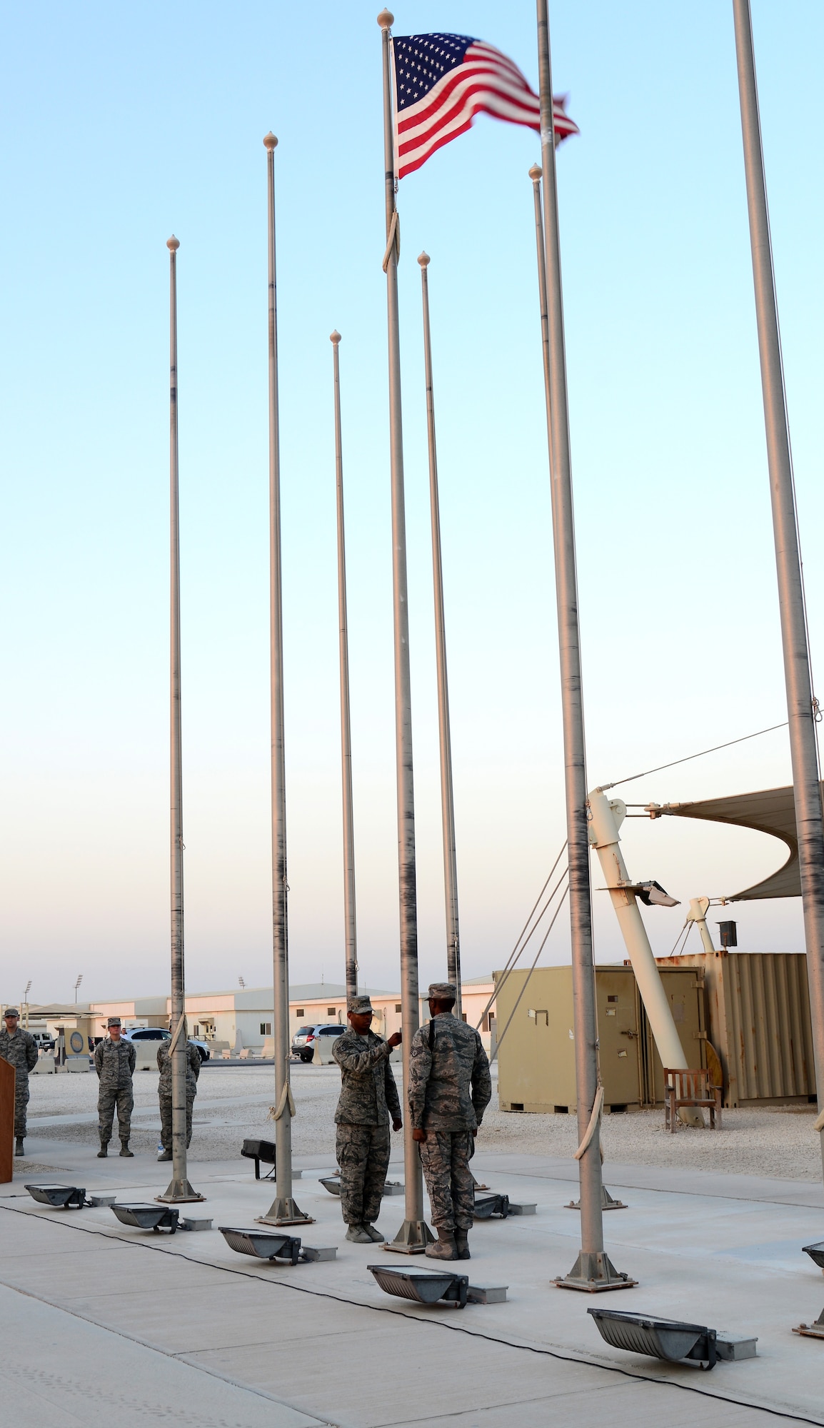 U.S.  Air Force Airmen from the 379th Air Expeditionary Wing Honor Guard lower the American flag during a retreat ceremony, Nov. 11, 2014, at Al Udeid Air Base, Qatar. During the retreat ceremony, Brig. Gen. Darren Hartford, 379th Air Expeditionary Wing commander, thanked coalition partners for attending the retreat and other remembrance events throughout the day and also thanked them for their service. (U.S. Air Force photo by Senior Airman Kia Atkins)