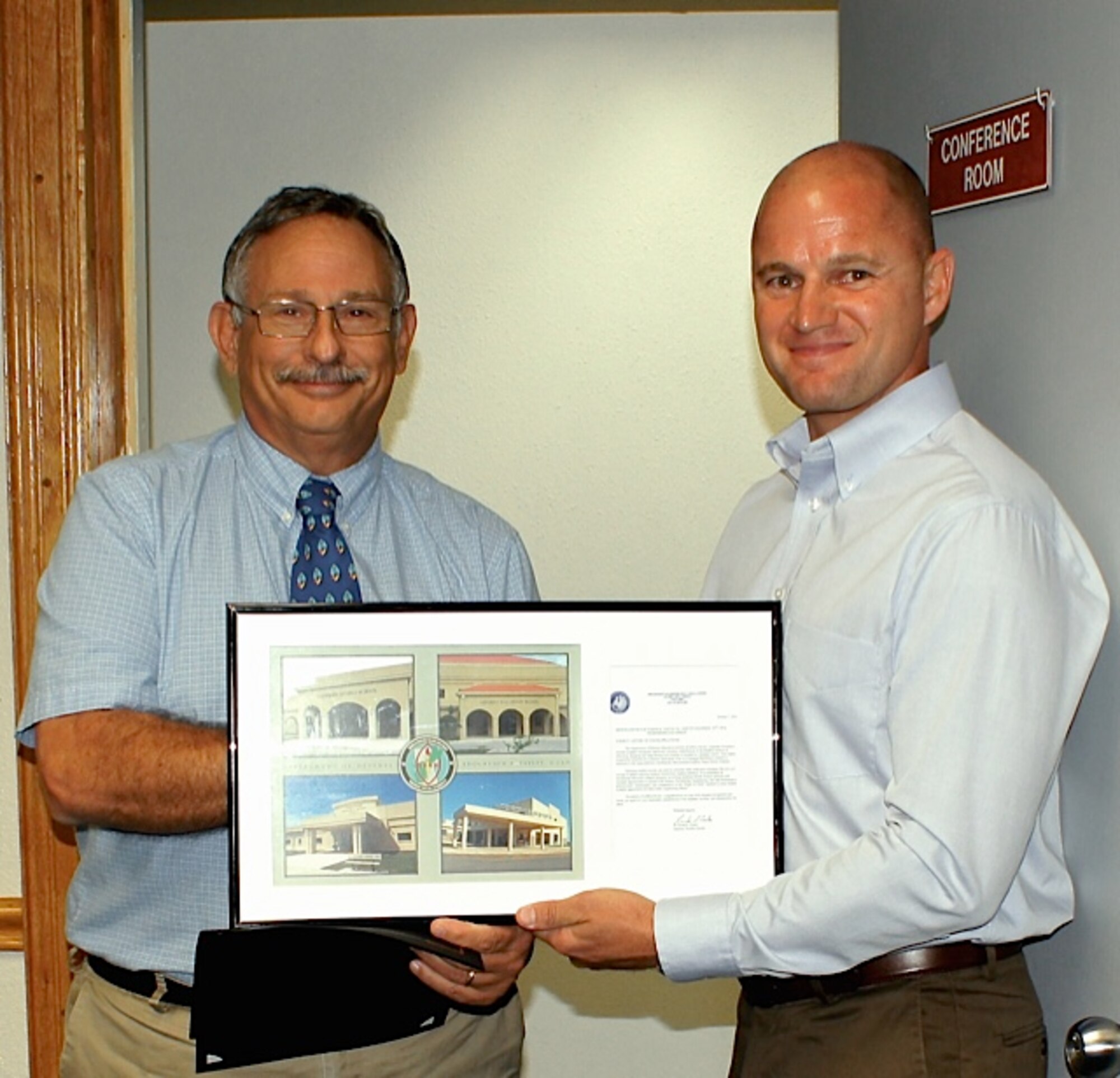 Dr. Steven Bloom, Department of Defense Education Activity superintendent, left, awards Joseph Vinch, 36th Civil Engineer Squadron deputy base civil engineer, the DoDEA Pacific 2014 Military Unit Excellence award Nov. 5, 2014, on Andersen Air Force Base, Guam. Vinch along with 36 CES engineers teaches the students of Andersen Middle school about the basics of engineering. (Courtesy photo)