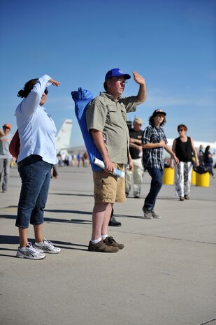 Amparo and Jeff Pittman, of Las Vegas, watch the P-51 Mustang perform at the Nellis Open House at Nellis Air Force Base, Nev., Nov. 9, 2014. The open house featured numerous aircraft representing America's aviation history on display alongside some of the nation's newest military aircraft. (U.S. Air Force photo by Tech. Sgt. Sanjay Allen)