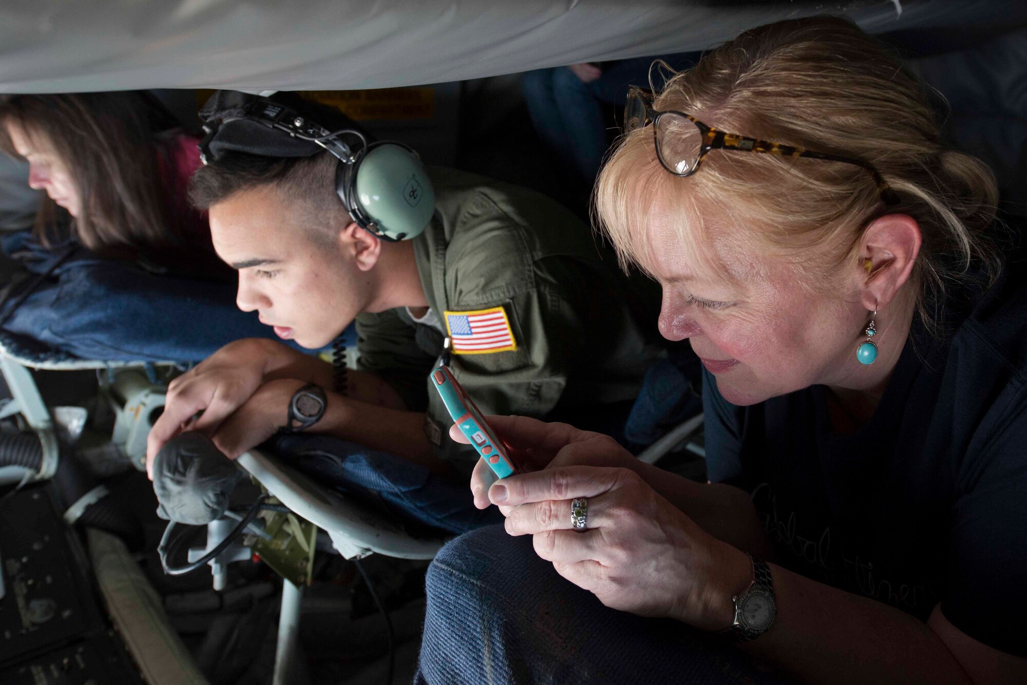 Keirston Lyons, a Fairchild honorary commander, Senior Airman Stephon Sharief, a 92nd Air Refueling Squadron boom operator, and Mary Starkey, a Fairchild honorary commander wait for anF-15E Strike Eagle during an incentive inflight refueling mission over Nevada airspace Nov. 6, 2014. The honorary commanders were given a chance to watch as the boom operator transferred fuel to a fighter jet as part of a training mission. (U.S. Air Force photo/Staff Sgt. Alexandre Montes)