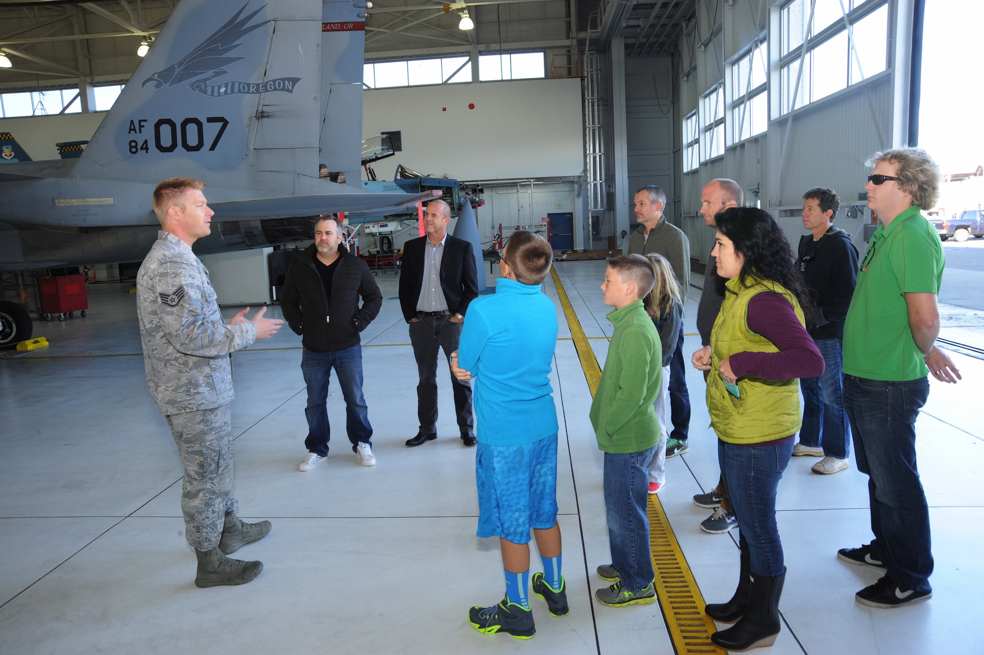Staff Sgt. Nick Hicks, assigned to the 142nd Fighter Wing Aircraft Maintenance Squadron, leads a tour group around aircraft 84-007, Oct. 16, 2014, a week before the test flight and after nearly two years of repairs, Portland Air National Guard Base, Ore. (U.S. Air National photo by Tech. Sgt. John Hughel, 142nd Fighter Wing Public Affairs)