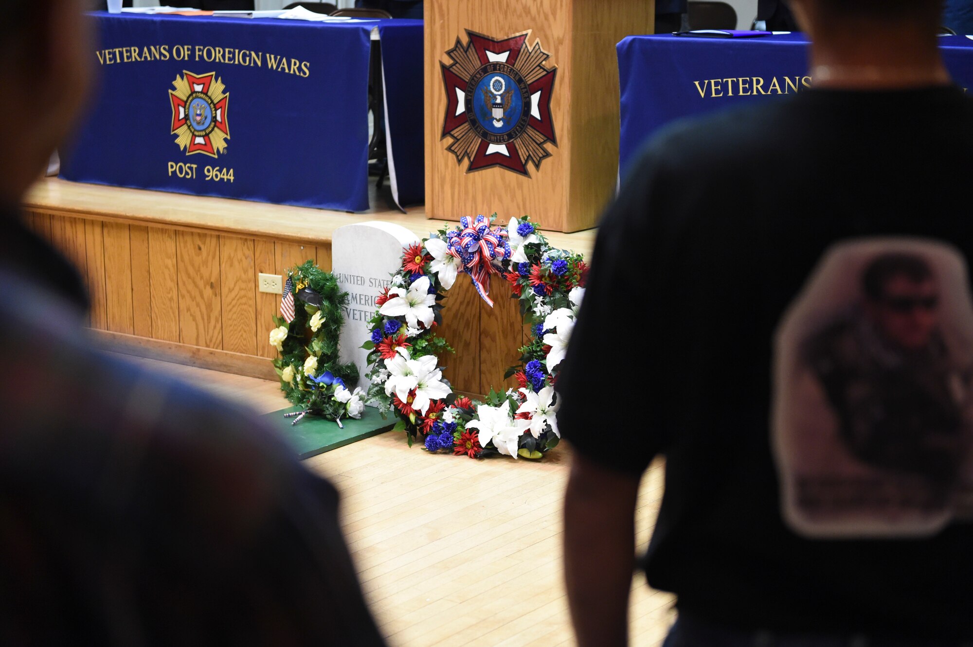 Fort Logan National Cemetery’s Veterans Day remembrance attendees pay their respects after a wreath-laying ceremony in honor of fallen service members Nov. 11, 2014, in Englewood, Colorado. The 37th annual remembrance, moved indoors due to inclement weather, included several guest speakers and patriotic music in addition to the wreath ceremony. (U.S. Air Force photo by 1st Lt. Trevor Zakrzewski/Released)