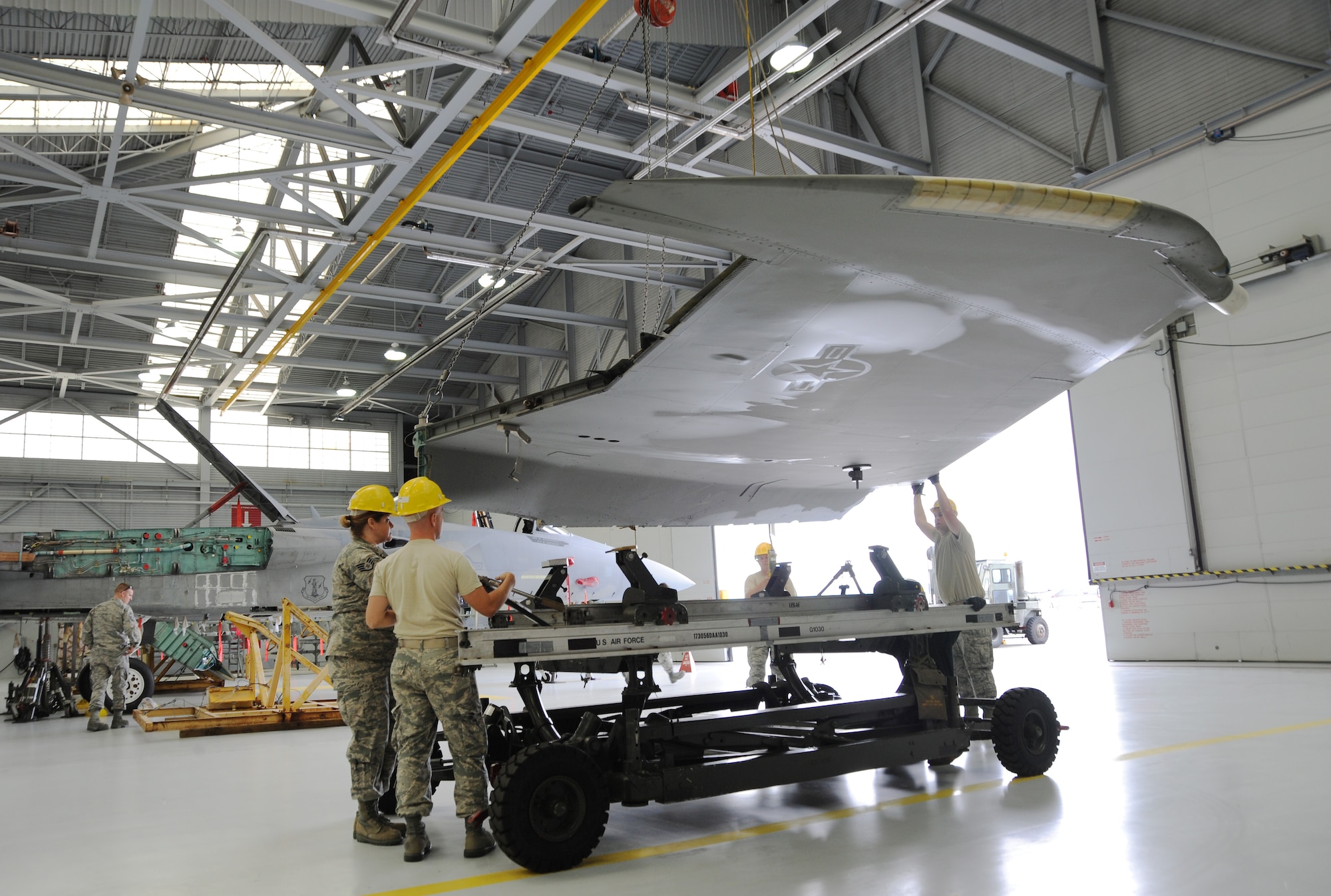 Contractors from Warner Robins Air Force Base, Georgia and 142nd Fighter Wing maintenance Airmen begin to reattach the wings to aircraft 84-007, June 3, 2014, Portland Air National Guard Base, Ore. (U.S. Air National photo by Tech. Sgt. John Hughel, 142nd Fighter Wing Public Affairs)