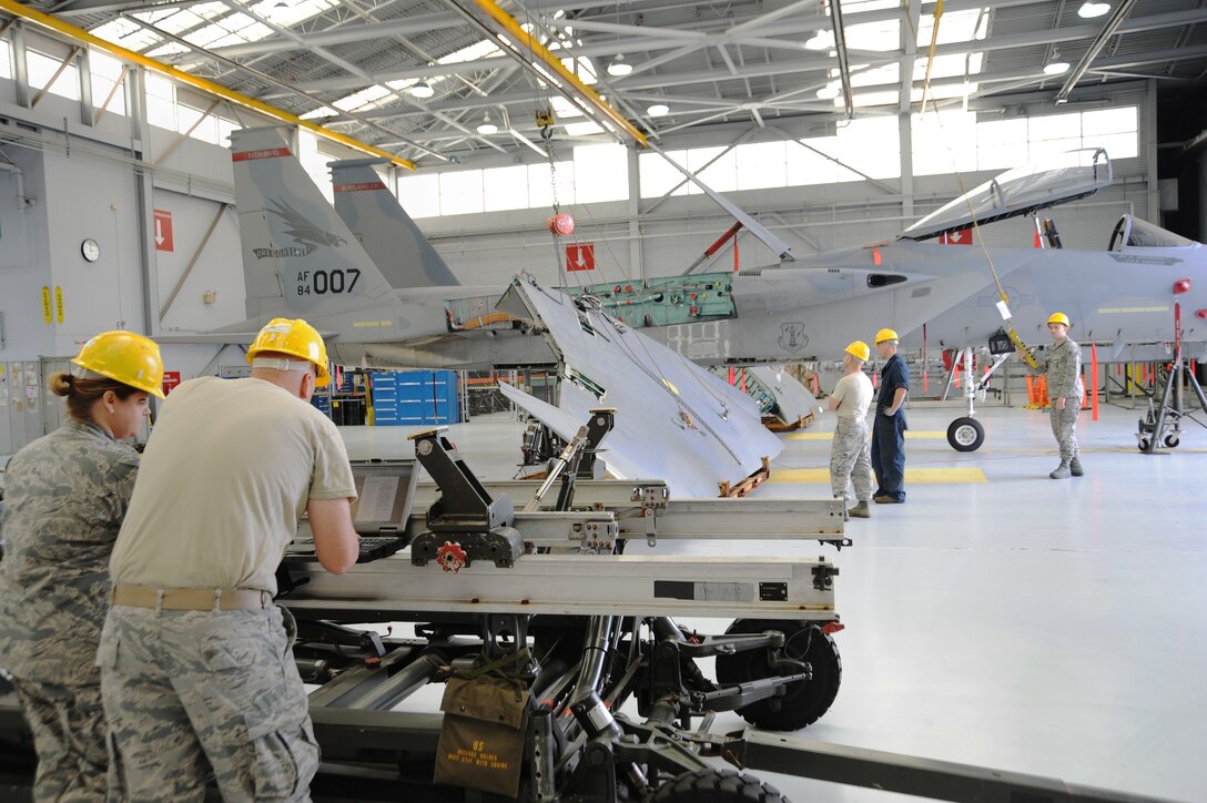 Contractors from Warner Robins Air Force Base, Georgia and 142nd Fighter Wing maintenance Airmen begin to reattach the wings to aircraft 84-007, June 3, 2014, Portland Air National Guard Base, Ore. (U.S. Air National photo by Tech. Sgt. John Hughel, 142nd Fighter Wing Public Affairs)