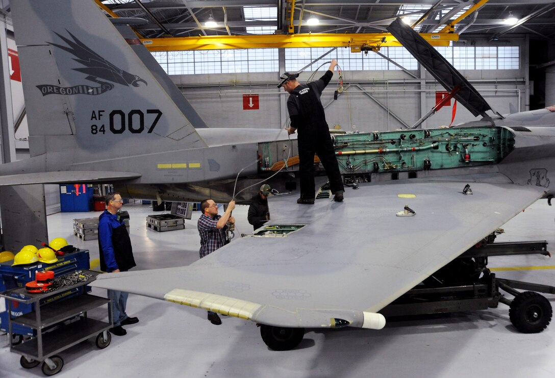 Contractors from Warner Robins Air Force Base, Georgia, begin the process of removing the wings from aircraft 84-007, Jan. 30, 2014, Portland Air National Guard Base, Ore. (U.S. Air National photo by Tech. Sgt. John Hughel, 142nd Fighter Wing Public Affairs)