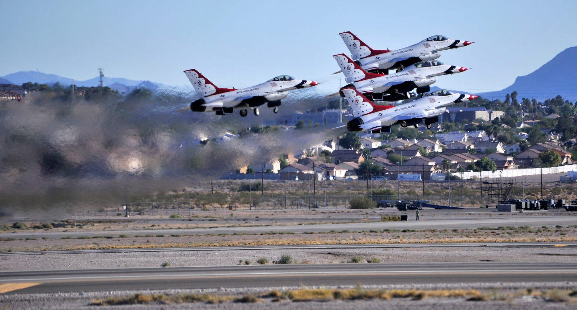 The U.S. Air Force Aerial Demonstration Team Thunderbirds take off for their performance during the Nellis Air Force Base 2014 Open House at Nellis AFB, Nevada, Nov. 8, 2014. The two-day open house featured performances from legacy aircraft such as the P-51 Mustang, and modern aircraft such as the F-22 Raptor. (U.S. Air Force photo by Airman 1st Class Christian Clausen/Released)