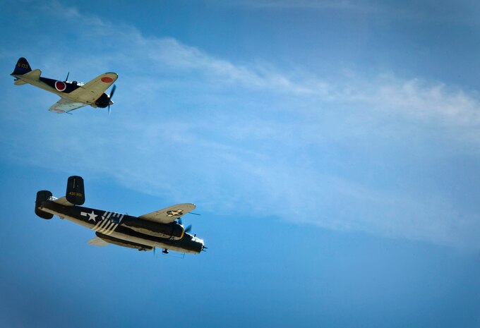 An A6M Zero and a B-25J Mitchell perform during the open house at Nellis Air Force Base, Nev., Nov. 9 2014. The two aircraft were a part of the Legacy Boombers act which performed a World War II reenactment. (U.S. Air Force photo by Airman 1st Class Rachel Loftis)
