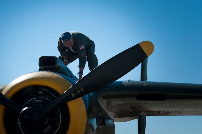 Ron “Rocky” Reinert, volunteer crewman, performs post-flight checks on a B-25J Mitchell during the open house at Nellis Air Force Base, Nev. Nov.7, 2014. The B-25, which is a twin-engine bomber that became standard equipment for the Allied Air Forces in World War II, was perhaps the most versatile aircraft of the war. (U.S. Air Force photo by Airman 1st Class Rachel Loftis)