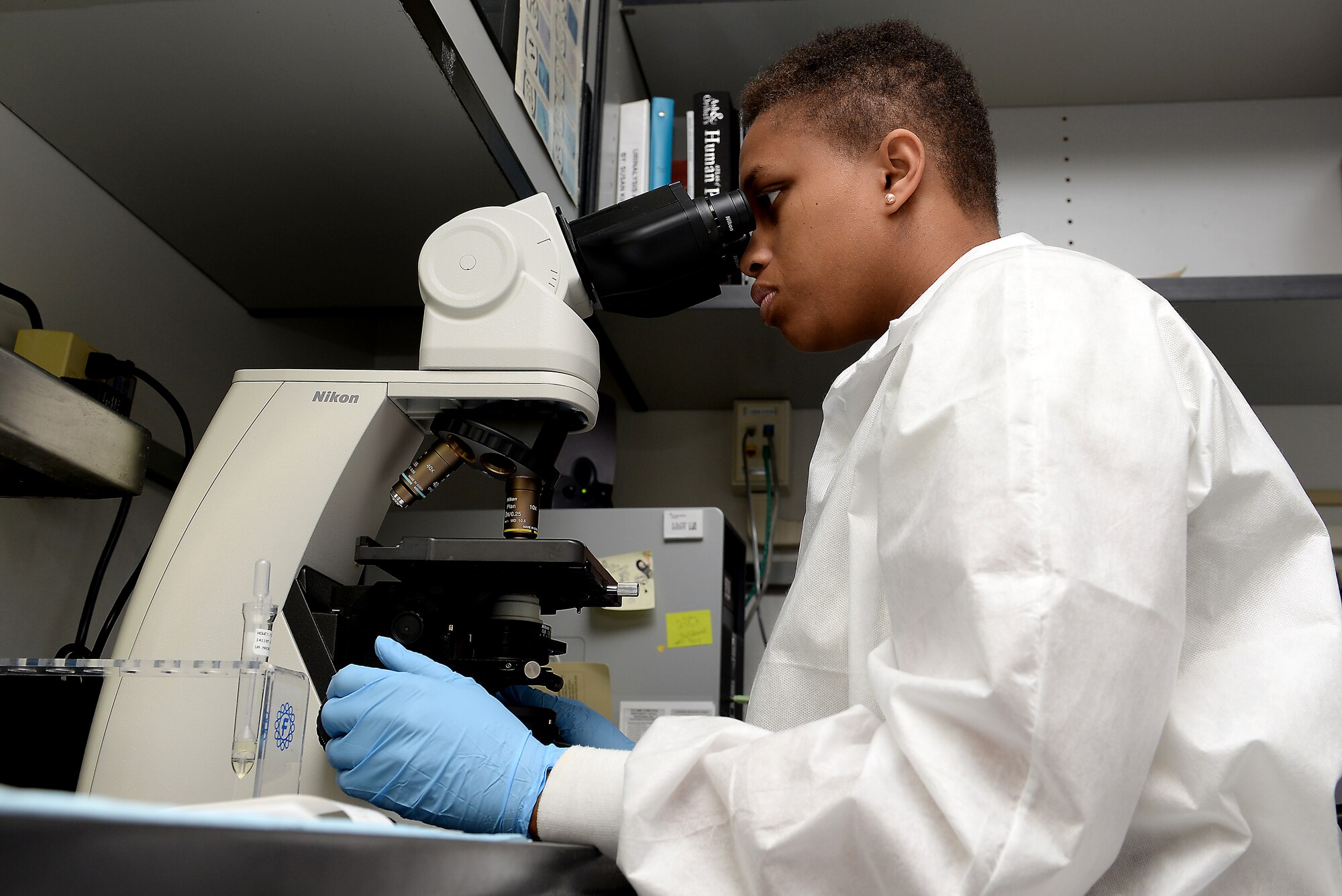 Senior Airman India King examines samples at the clinic laboratory Nov. 5, 2014 at Scott Air Force Base, Ill. After King’s pregnancy she had to undergo many surgeries due to eclampsia, but is recovering with the help of family and co-workers. (U.S. Air Force photo/ Airman 1st Class Kiana Brothers)