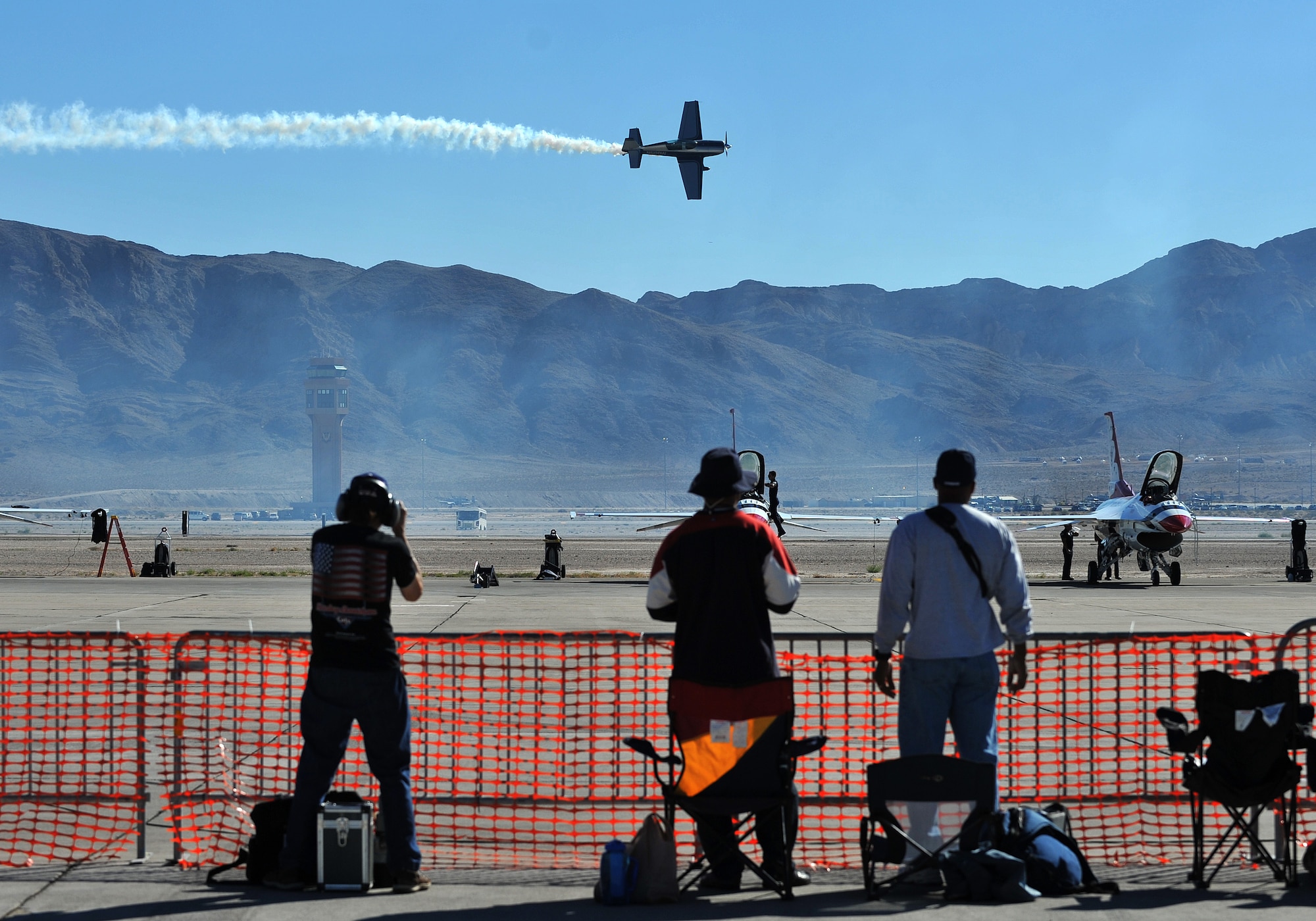 Spectators watch a Korean Conflict reenactment during the Nellis Air Force Base 2014 Open House Nov. 7, 2014, at Nellis AFB, Nevada. The two-event included aircraft demonstrations, statics displays, and a performance by the United States Air Force Aerial Demonstration Team Thunderbirds. (U.S. Air Force photo by Senior Master Sgt. Cecilio Ricardo)