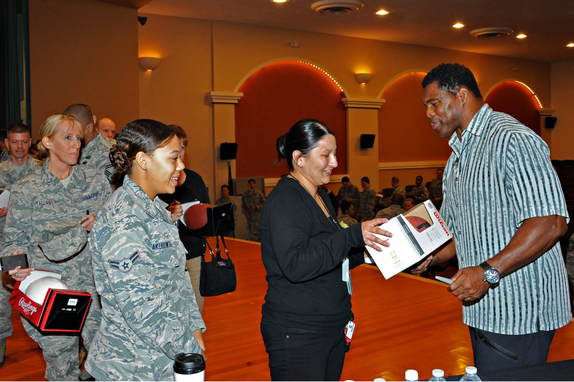 Herschel Walker, former National Football League running back and Patriots Support Program Anti-Stigma Campaign spokesman, signs autographs for members of Team Beale during his visit to promote and educate Airmen on mental health awareness Nov. 6, 2014, at Beale Air Force Base, Calif. Walker began to promote mental health awareness after publishing his book, which discusses his experience with dissociative identity disorder. (U.S. Air Force photo by Airman 1st Class Ramon A. Adelan/Released)