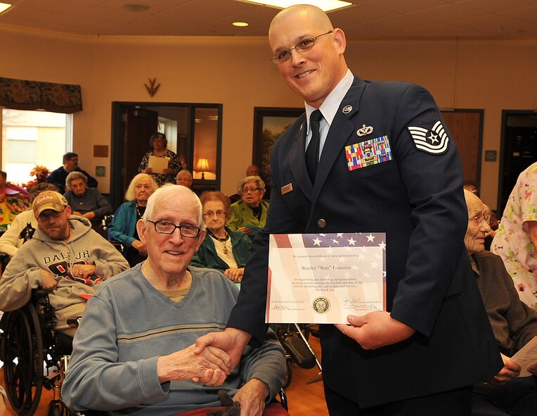 Tech. Sgt. Joshua Robistow, 319th Civil Engineer Squadron unit training manager, presents Stanley “Stan” Fontaine, a U.S. Army veteran, with a certificate of appreciation in honor of Fontaine’s military service Nov. 11, 2014, at Valley Elder Care Center in Grand Forks, N.D. Approximately 120 people attended the Veterans Day service at the center where 40 other veterans also received certificates of appreciation. (U.S. Air Force photo/Airman 1st Class Bonnie Grantham)