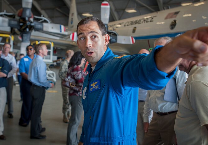 Lt  . Cmdr. Jason Mansour, G-IV SP Hurricane Hunter pilot, speaks with a group of Joint Base Charleston civic leaders Nov. 4, 2014, inside Hangar 5 at MacDill Air Force Base, Fla. The NOAA mission includes the “Hurricane Hunters,” teams of scientists who fly into hurricanes for scientific purposes. (U.S. Air Force photo/Senior Airman Tom Brading)