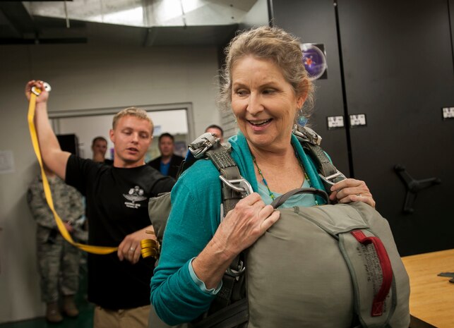 Deb Campeau, Business Development HCA/Trident Health vice president, puts on more than 40 pounds of weight at the parachute rigging building, Nov. 4, 2014, at MacDill Air Force Base, Fla. Joint Base Charleston civic leaders participated in a military tour highlighting the 6th Air Mobility Wing mission. (U.S. Air Force photo / Senior Airman Tom Brading)