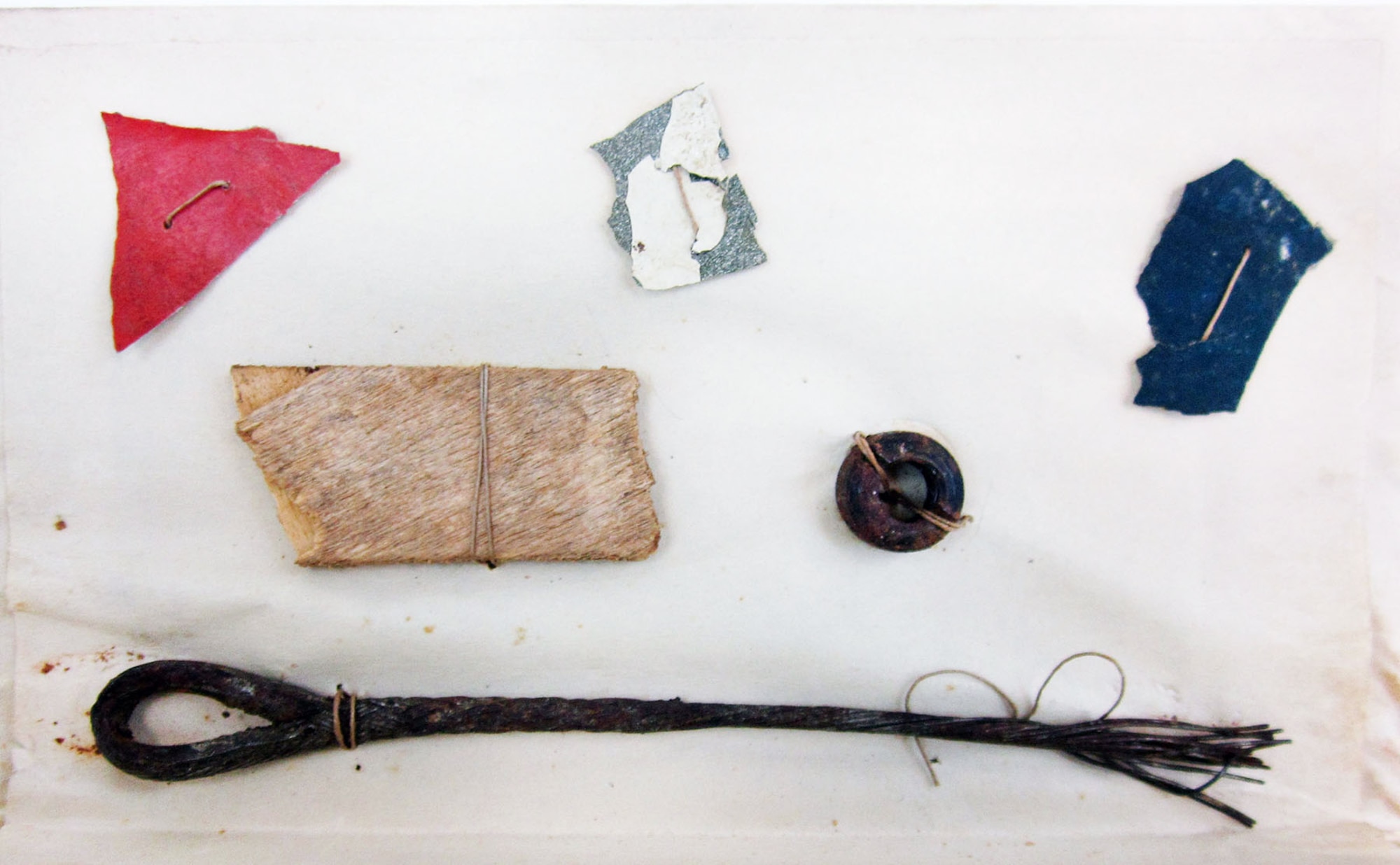 These six pieces of aircraft were taken from Lt. Quentin Roosevelt's Nieuport 28 at the crash site by Sgt. Mark Thatcher on July 14, 1918. There are three small pieces of painted aircraft fabric (red, white, blue), a small piece of wood and two pieces of hardware (nut and wire). Roosevelt, the son of former President Theodore Roosevelt, arrived in France during World War I as a supply officer and trained to become a pilot. As a pilot, he flew a Nieuport 28 with the 95th Aero Squadron. Roosevelt died when his plane was shot down behind German lines by Sgt. Karl Thom, a German ace with 24 victories, on July 14, 1918. (U.S. Air Force photo)
