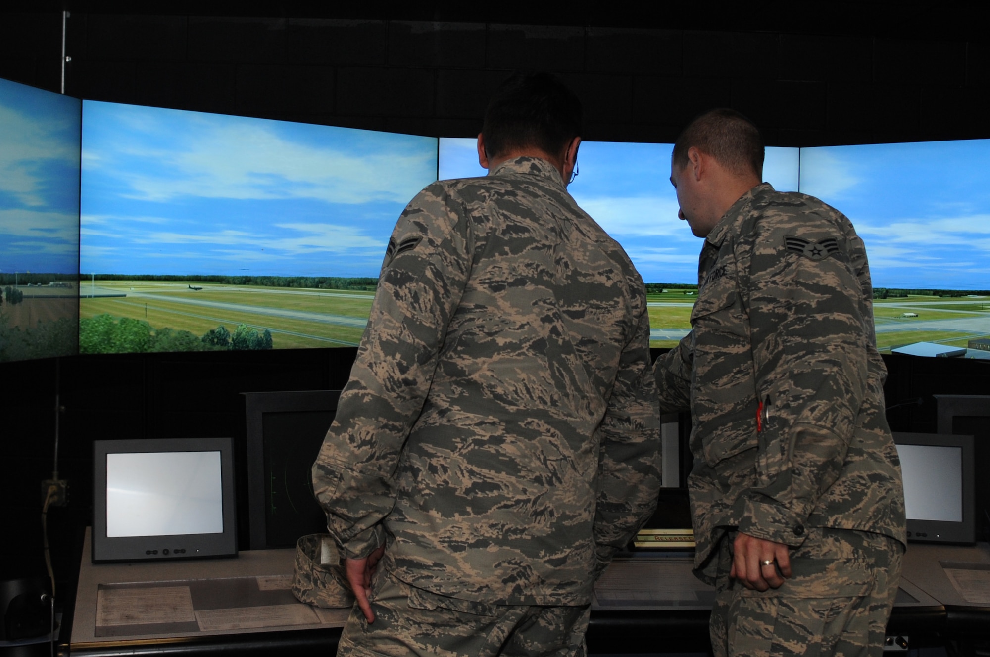 Senior Airman Jake Jansen, 4th Operations Support Squadron air traffic controller, teaches Airman 1st Class Erian Eady, 4th Logistics Readiness Squadron personal property counselor, how to manage the runway and surrounding airspace during the first 4th Fighter Wing Mission Immersion Day in the 4th Operations Support Squadron air traffic control simulator building at Seymour Johnson Air Force Base, North Carolina, Nov. 7, 2014. The day’s activities also included a tour of the base operations building and a briefing from the 4th OSS weather flight. (U.S. Air Force photo/Senior Airman Ashley J. Thum)