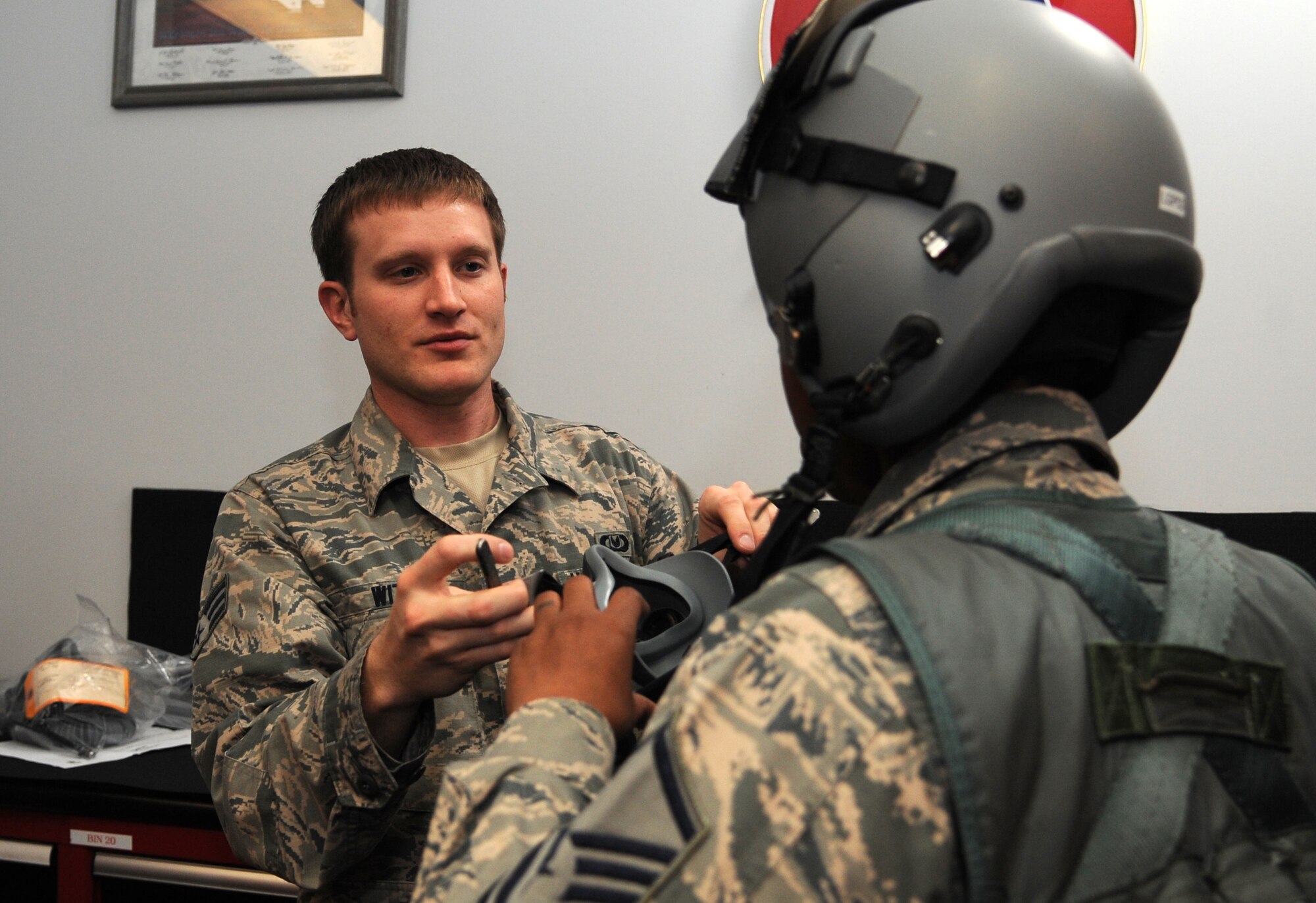 Senior Airman Hunter Witt, 4th Operations Support Squadron aircrew flight equipment technician, helps Master Sgt. Angela Baker, 4th Medical Support Squadron medical readiness flight chief, secure a helmet and oxygen mask during the first 4th Fighter Wing Mission Immersion Day in the 333rd Fighter Squadron at Seymour Johnson Air Force Base, North Carolina, Nov. 7, 2014. Mission Immersion Day will soon become a monthly event hosted by each fighter squadron in turn. The day was designed to give Airmen fulfilling support roles across the base a better understanding of how flying operations are conducted and how their efforts make it possible. (U.S. Air Force photo/Senior Airman Ashley J. Thum)