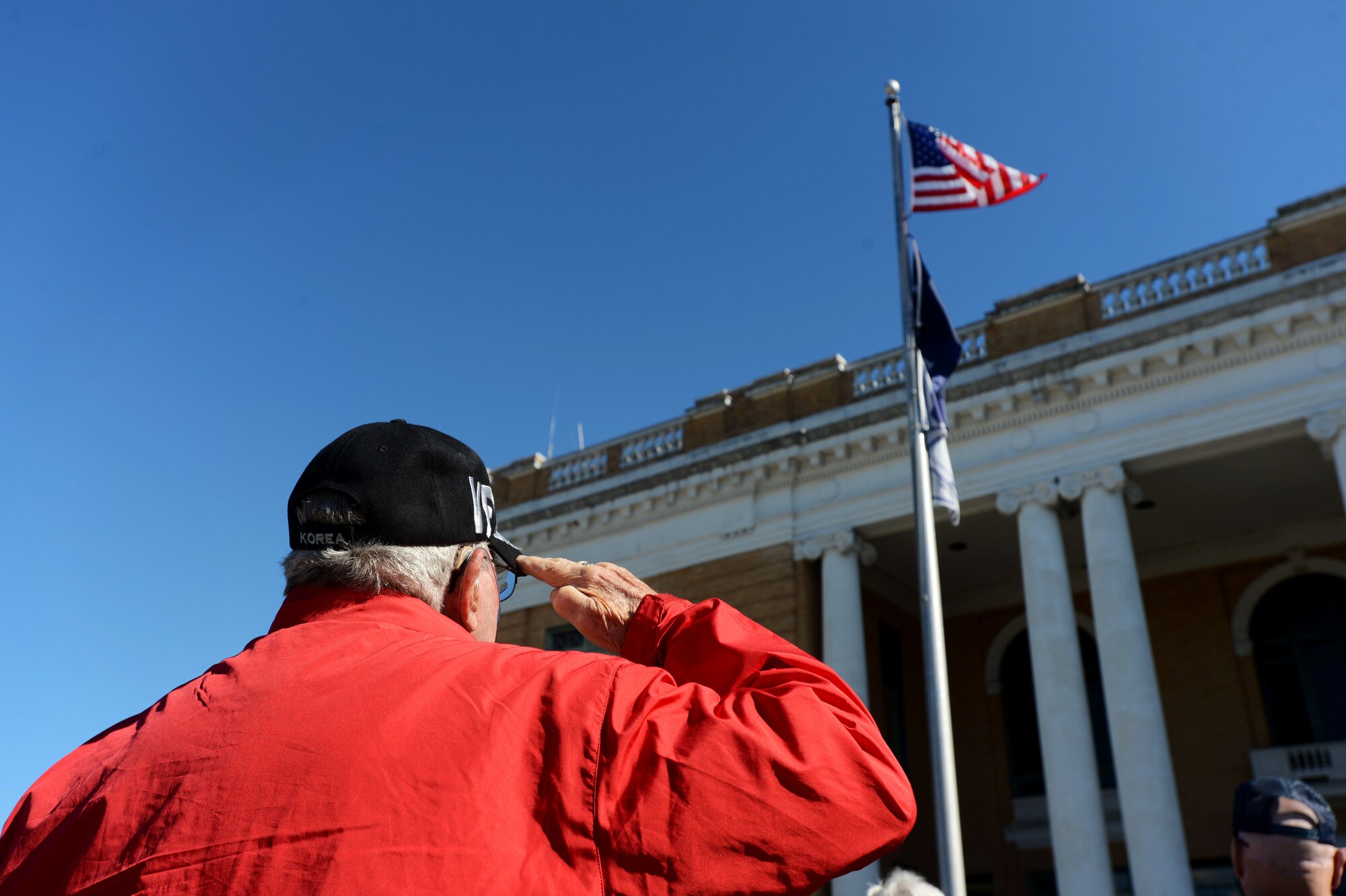 A veteran renders a salute to the flag during the playing of taps while attending a Veterans Day ceremony at the Sumter County Courthouse, Sumter, S.C., Nov. 11, 2014. Along with taps, the Pledge of Allegiance, Presentation of the Colors, and National Anthem were observed at the event. (U.S. Air Force photo by Airman 1st Class Jensen Stidham/Released)
