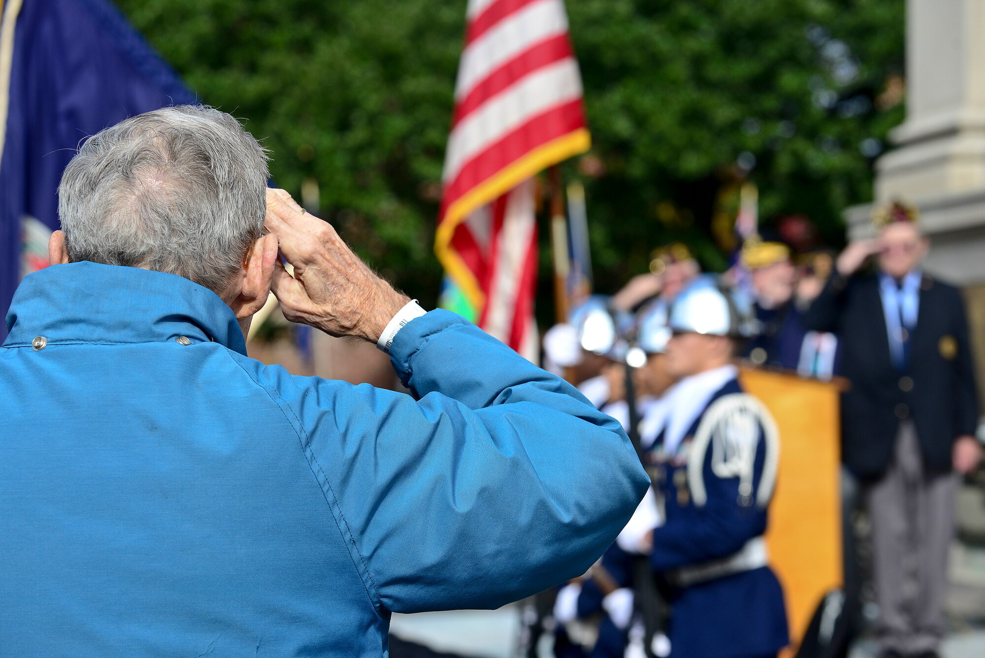 A member of the crowd salutes the flag during the ”Star Spangled Banner” at a Veteran’s Day ceremony at the Victory Arch in Newport News, Va., Nov. 11, 2014. The colors were presented by a U.S. Air Force JROTC unit from Menchville High School. (U.S. Air Force photo by Senior Airman Kimberly Nagle/Released)