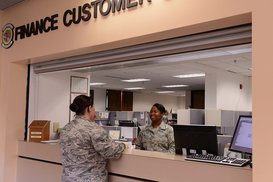 U.S. Air Force Staff Sgt. Jaimie Gill, 20th Comptroller Squadron financial services supervisor, assists an Airmen at the finance customer service desk at Shaw Air Force Base, S.C., Nov. 12, 2014. The finance Airmen manage the annual funds for Shaw and ensure all military members, retirees, and civilian employees are paid on time and correctly. (U.S. Air Force photo by Airman 1st Class Diana M. Cossaboom/Released)