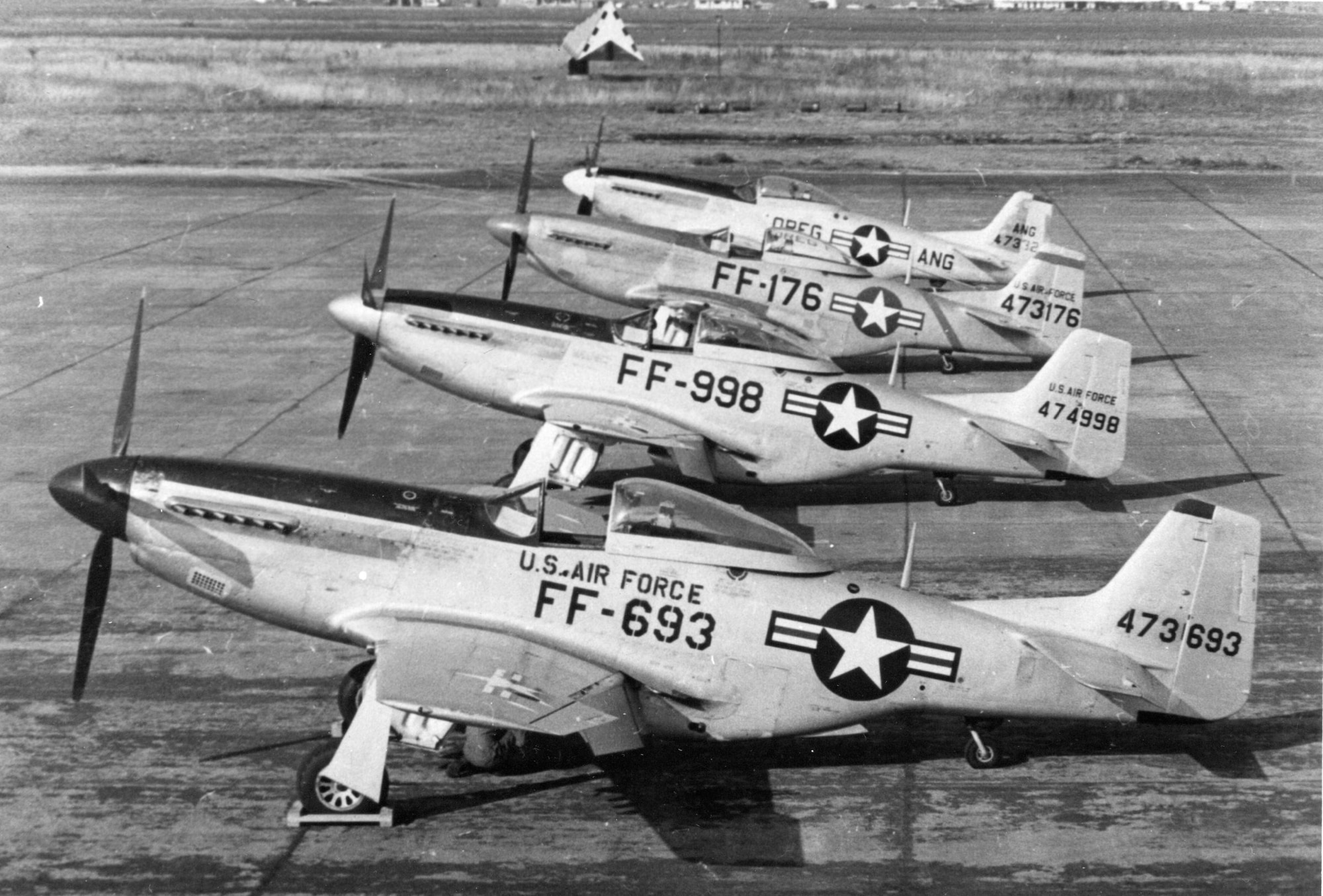 Three North American F-51D Mustang fighters rest beside an Oregon example of the type in this post-1948 view at Portland Air Base.  The trio of Mustangs could be either replacement aircraft for the OreANG or transients enroute to another destination.  The Mustang was the 142nd Fighter Group’s primary aircraft assigned after World War II and on into the Korean War era, found in squadron-level strength in the 123rd Fighter Squadron.  The group also had a small utility flight composed of other support aircraft types in small numbers.  The Caretaker role was essential to keeping all of the OreANG’s aircraft operational as well as handling transient aircraft. (Courtesy 142nd Fighter Wing History Archives)