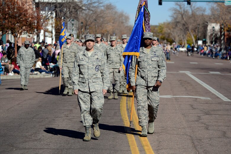 Col. Bill Liquori, 50th Space Wing commander, and Chief Master Sgt. Lavon Coles, 50 SW command chief, lead the wing during the Colorado Springs Veterans Day Parade Nov. 8, 2014, in Colorado Springs, Colo. Members of Fort Carson, Cheyenne Mountain Air Force Station and Schriever and Peterson Air Force Bases marched in the parade or rode on floats. (U.S. Air Force photo/Christopher DeWitt)     