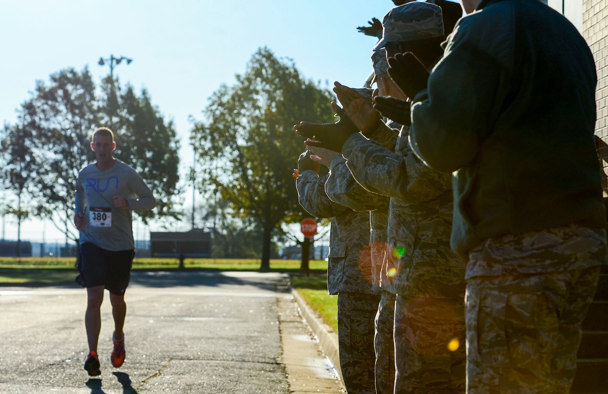U.S. Air Force members of the Langley Air Force Base First Sergeants Council cheer on a runner during the Operation Warmheart 5k food run at Langley Air Force Base, Va., Nov. 7, 2014. Operation Warmheart is a non-profit organization that distributes charitable funds to Joint Base Langley-Eustis Service members and their families all year long, with the organization dispersing the majority of its funding during the holiday season. (U.S. Air Force photo by Senior Airman Kayla Newman/Released)