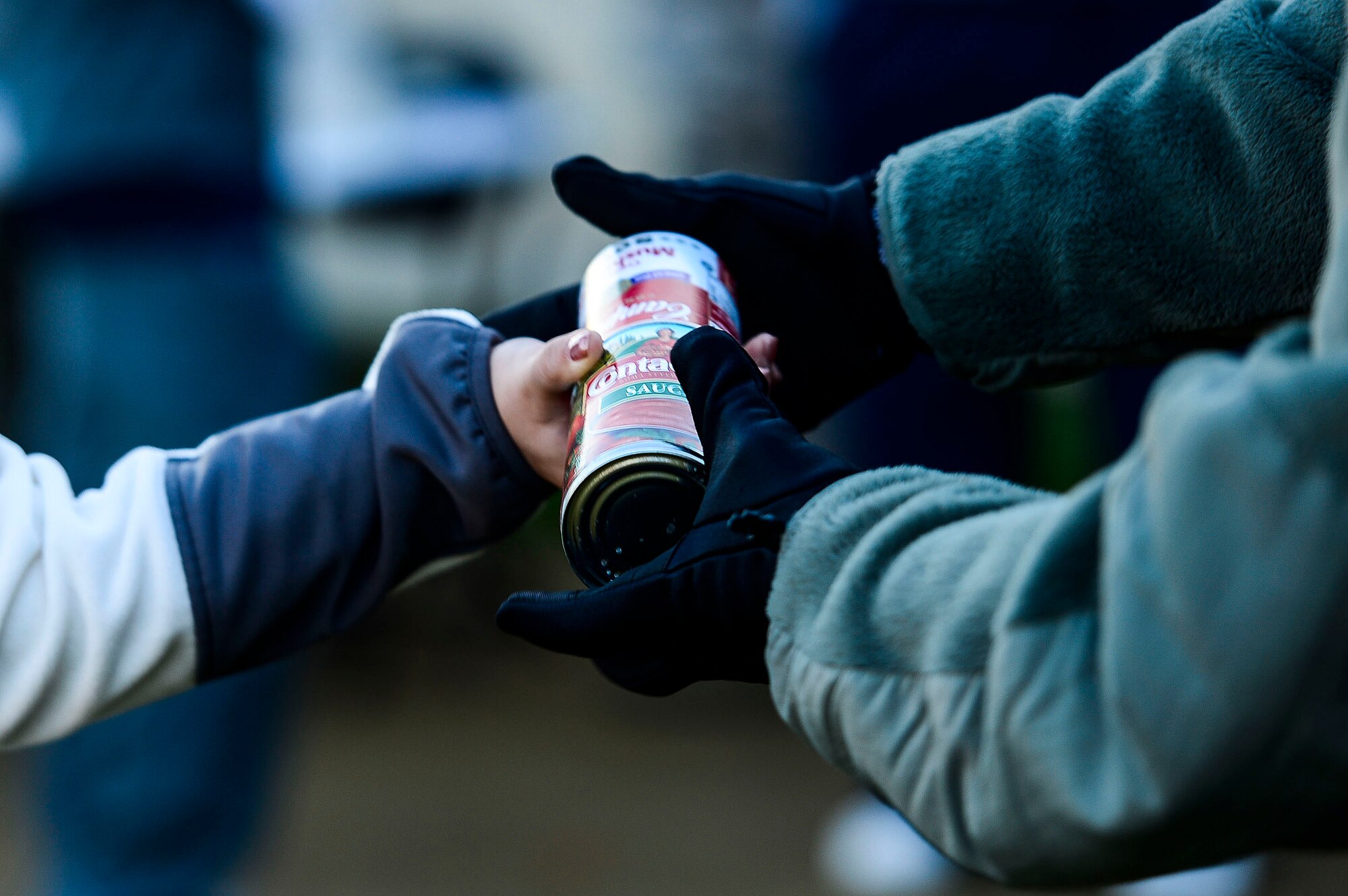 A runner hands canned goods to a member of the Langley First Sergeants Council as part of the proceeds for the Operation Warmheart 5k food run at Langley Air Force Base, Va., Nov. 7, 2014. Operation Warmheart is an outreach program for Langley and provides assistance to U.S. Air Force Airmen and their families year-round. (U.S. Air Force photo by Senior Airman Kayla Newman/Released)