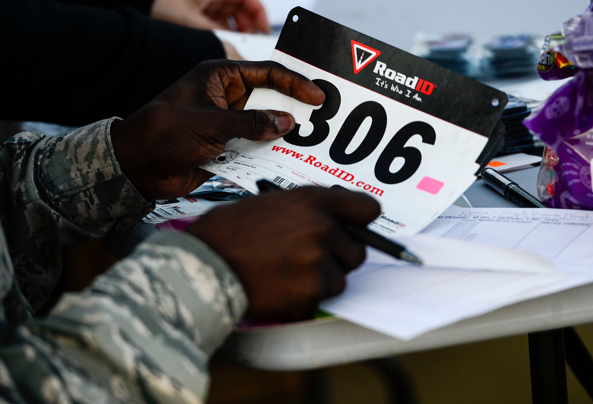 A U.S. Air Force Airman signs in a runner before the Operation Warmheart 5k food run at Langley Air Force Base, Va., Nov. 7, 2014. The run was hosted by the Langley First Sergeants Council to raise funds and canned goods for Operation Warmheart. (U.S. Air Force photo by Senior Airman Kayla Newman/Released) 