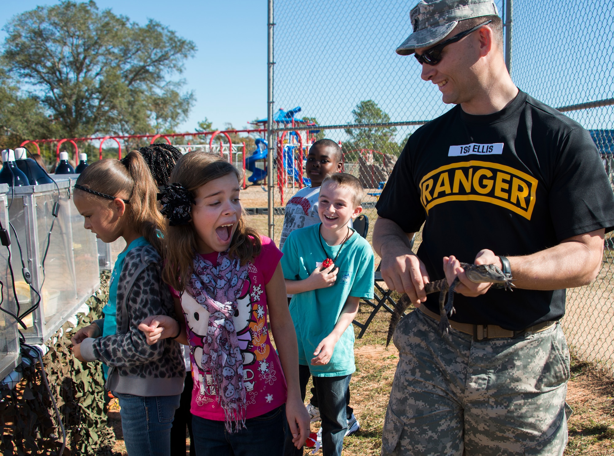 Kids react to a baby alligator held by Sgt. 1st Class Travis Ellis, 6th Ranger Training Battalion, during a Veteran’s Day celebration held at Riverside Elementary in Crestview, Fla., Nov. 10.  Airmen from explosive ordnance disposal, life support, honor guard and 6th RTB Soldiers were on hand to interact with the children in this first-ever school event.  (U.S. Air Force photo/Tech. Sgt. Jasmin Taylor)
